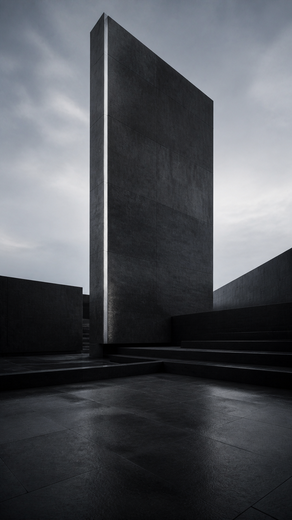 A monumental dark stone tower standing against an open gray sky